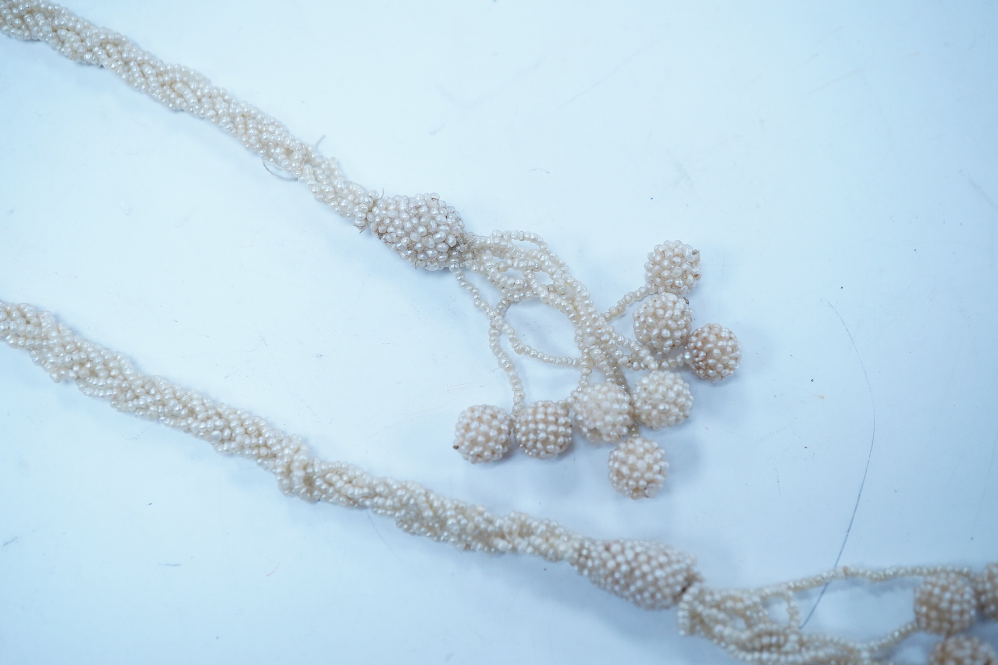 An antique multi strand seed pearl cluster set sautoir necklace, with spherical bead terminals, 56cm. Condition - fair to good